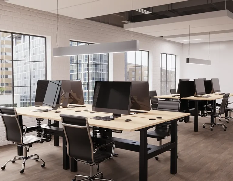 Office chairs arranged in front of back-to-back height adjustable desks in a spacious, modern office environment.